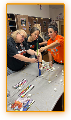 Three adults building a science project in the classroom